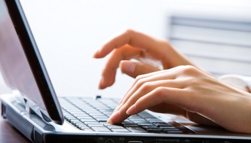 Человек набирает на ноутбуке текст