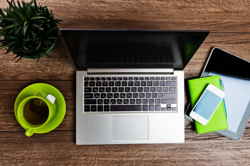 Ноутбук, планшет, смартфон, записная книжка и чашка с чаем