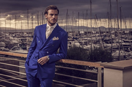 Богатый парень в костюме стоит на пирсе